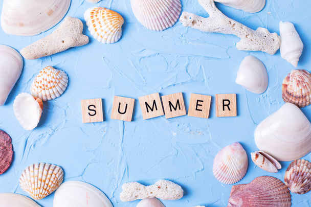 Marine decorations and word summer from wooden blocks on blue textured background - Foto, Bild