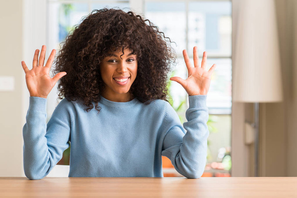 Africká americká žena v domácnosti ukazující a směřující nahoru s prsty číslo deset, zatímco s úsměvem a spokojené. - Fotografie, Obrázek