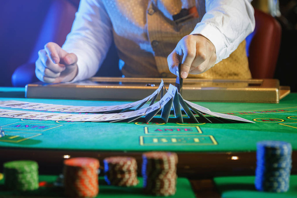 Professional croupier during cards shuffle in the casino - Photo, Image