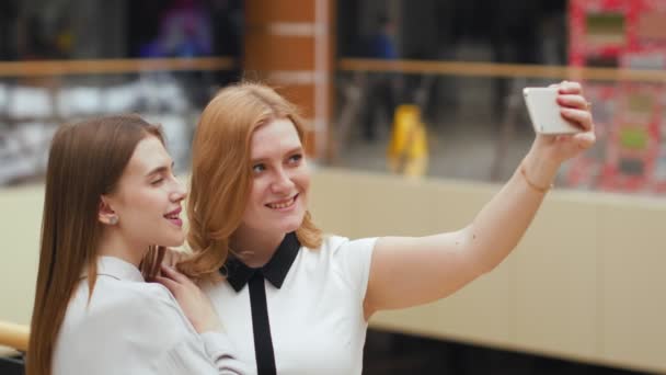 Twee gelukkige jonge vrouwen selfie maken in het winkelcentrum. - Video
