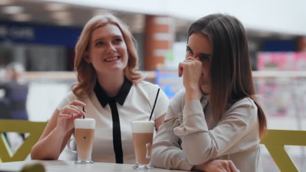 Dvě mladé ženy mluví a pije kávu sedí v kavárně. - Záběry, video