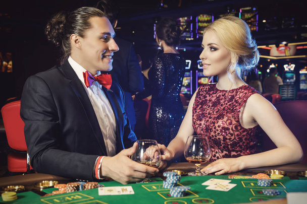 Young and beautiful couple playing poker in the casino - Foto, Imagem