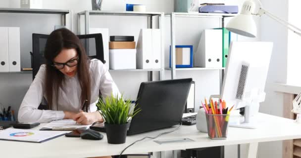 mulher de negócios preenchendo documentos e trabalhando no laptop no escritório moderno
 - Filmagem, Vídeo