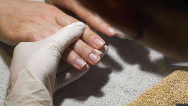 Vrouw krijgt nail manicure. Voorbereiden van vernis coating. - Video