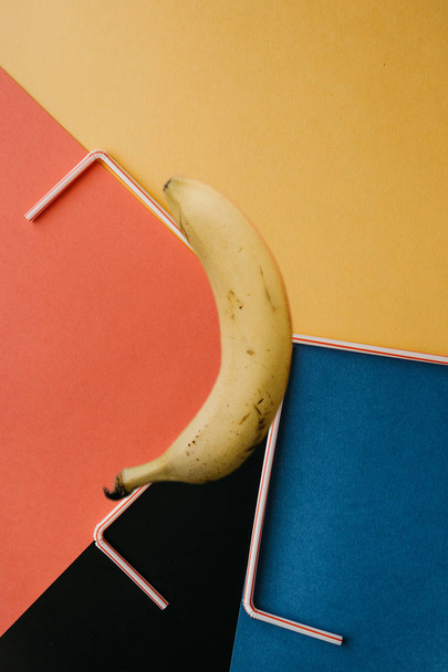 A kreatív fénykép egy banánt, és a kis csövek a világos háttér - Fotó, kép