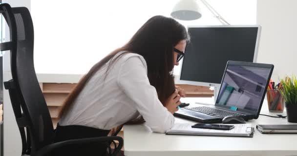 businesswoman setting aside cup and puting head on laptop - Video
