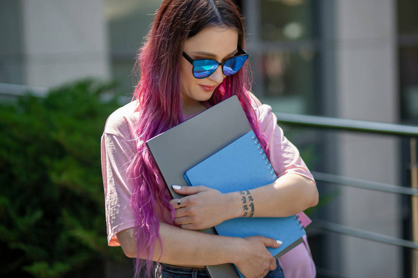 Портрет красивой женщины-писательницы в повседневной одежде с современным ноутбуком в руке
. - Фото, изображение