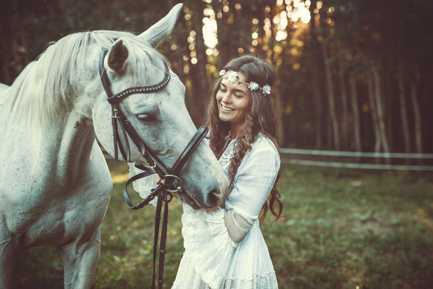 Young woman in beautiful white dress with beautiful horse - Photo, image
