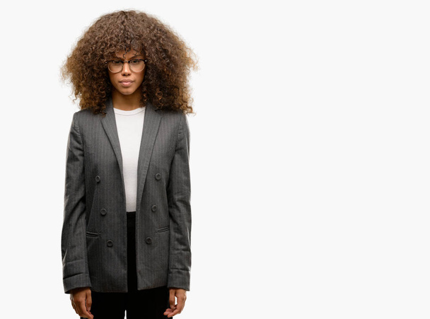 Femme d'affaires afro-américaine portant des lunettes sceptiques et nerveux, fronçant les sourcils bouleversés en raison de problèmes. Personne négative
. - Photo, image