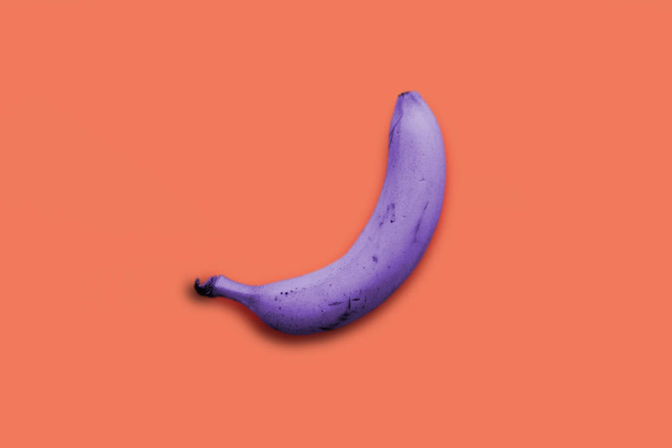 Creative idea purple banana on a pink background - Valokuva, kuva