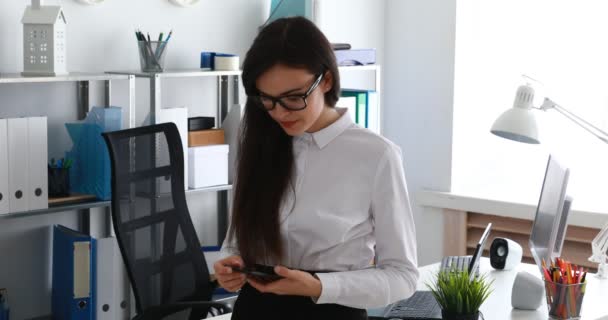 mujer de negocios hablando en smartphone y sonriendo en la oficina moderna
 - Imágenes, Vídeo