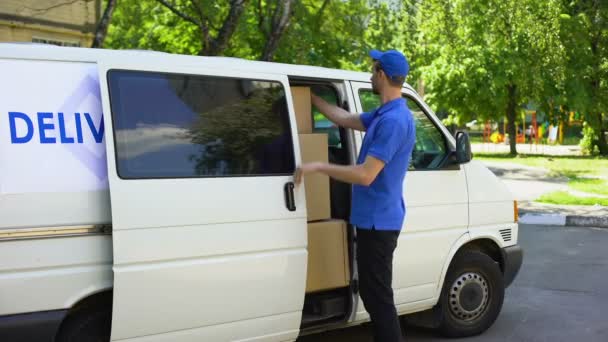 Deliveryman taking parcel box from van, courier service company, moving firm - Video, Çekim