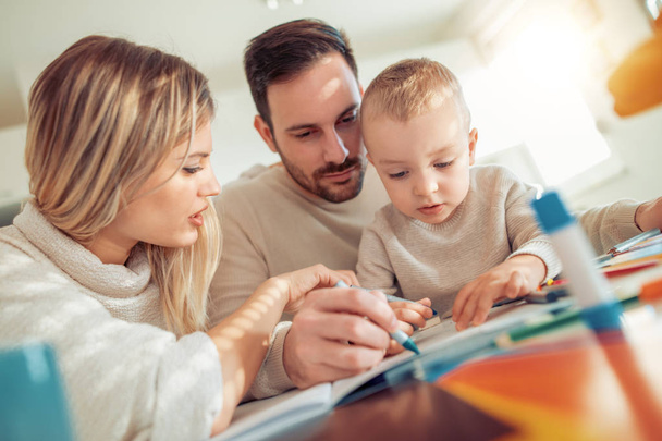 Mladá rodina kreslí společně doma. - Fotografie, Obrázek