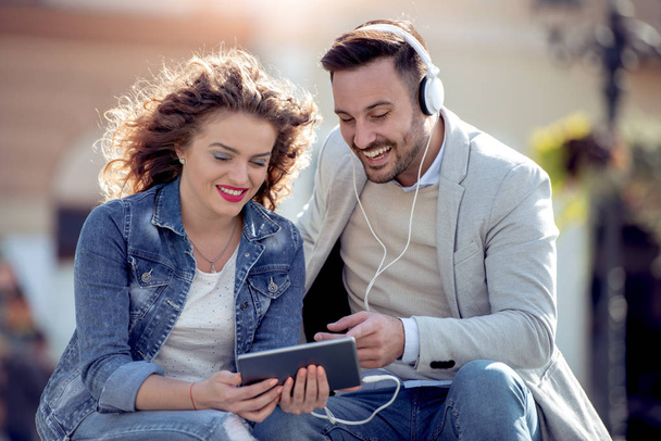 Paar in liefde luisteren muziek op koptelefoon in de stad. - Foto, afbeelding