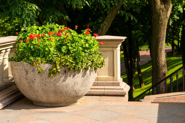 un gran jarrón para flores en un balcón de piedra en el parque
 - Foto, Imagen