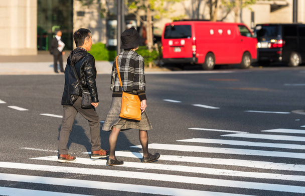 TOKYO, GIAPPONE - 7 NOVEMBRE 2017: Coppia sulla strada della città attraversa la strada. Copia spazio per testo
 - Foto, immagini