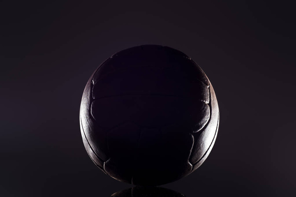 Старый футбольный кожаный мяч на черном фоне
 - Фото, изображение