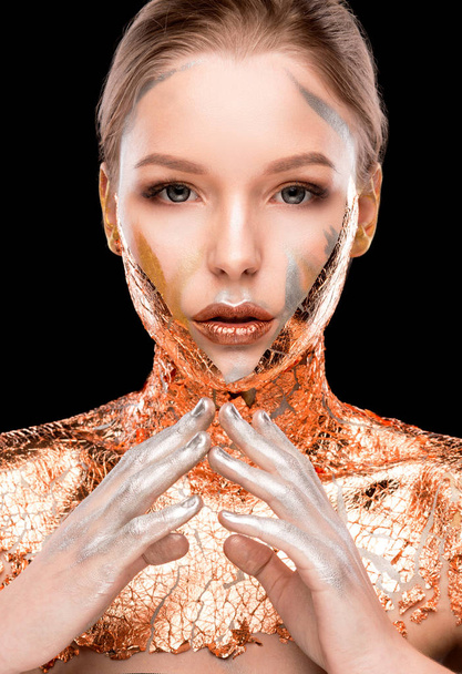 Красота съемки гламурной блондинки женщина с творческим макияжем и золотой фольгой на плечах и лице
 - Фото, изображение