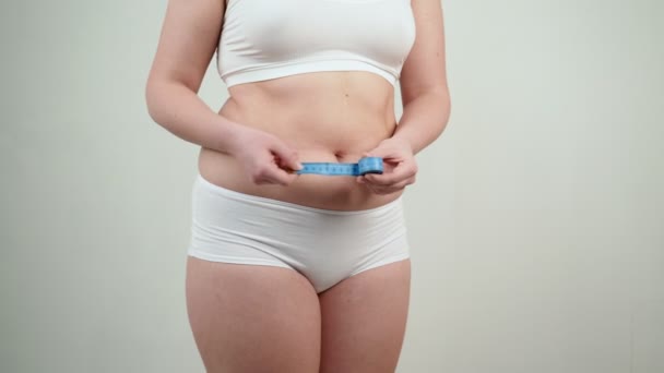 vrouw met overgewicht meten van haar dikke buik. - Video