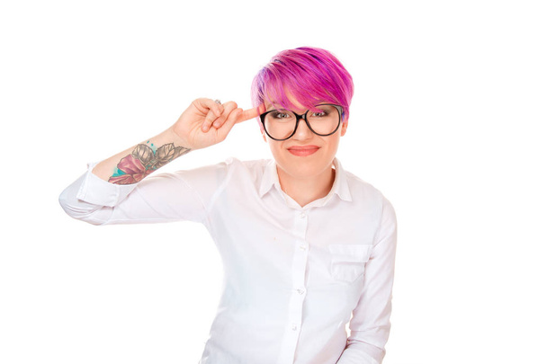 Millennial tattooed woman with pink hair twisting forefinger at temple showing crazy sign and looking at camera with disapprove on white background  - Фото, зображення
