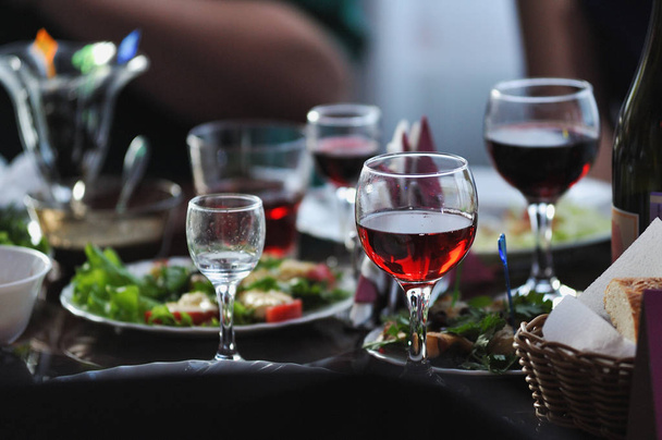 Stůl v restauraci s občerstvením a sklenice červeného vína. - Fotografie, Obrázek