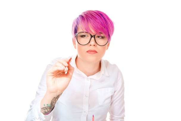 Pink haired woman in white buttoned shirt wearing glasses and writing with pencil in front looking pensive and puzzled and isolated on white - Fotoğraf, Görsel