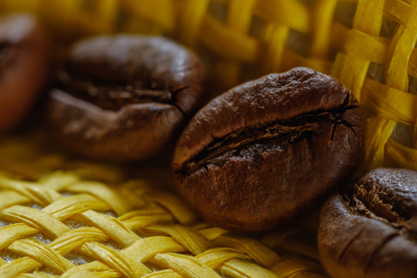 Set of fresh roasted macro coffee beans on yellow wicker basket background. - Fotografie, Obrázek
