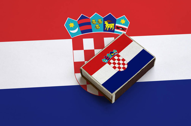 Σημαία Κροατία απεικονίζεται σε ένα Σπιρτόκουτο που βρίσκεται σε μια μεγάλη σημαία. - Φωτογραφία, εικόνα