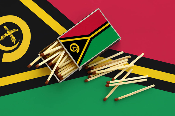 Vlajka Vanuatu je zobrazen na otevřené matchbox, z něhož několik odpovídá pádu a leží na velká vlajka. - Fotografie, Obrázek