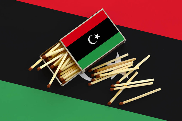 Σημαία της Λιβύης εμφανίζεται στο ένα ανοιχτό Σπιρτόκουτο, από την οποία αρκετοί αγώνες φθινόπωρο και βρίσκεται σε μια μεγάλη σημαία. - Φωτογραφία, εικόνα