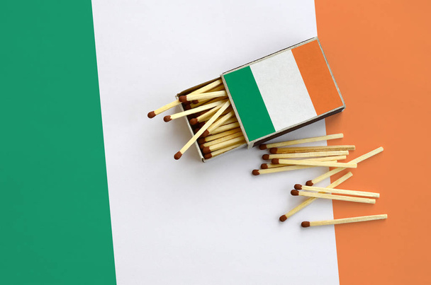 Flaga Irlandii jest się na otwarte matchbox, z których kilka pasuje do upadku i leży na dużą flagę. - Zdjęcie, obraz