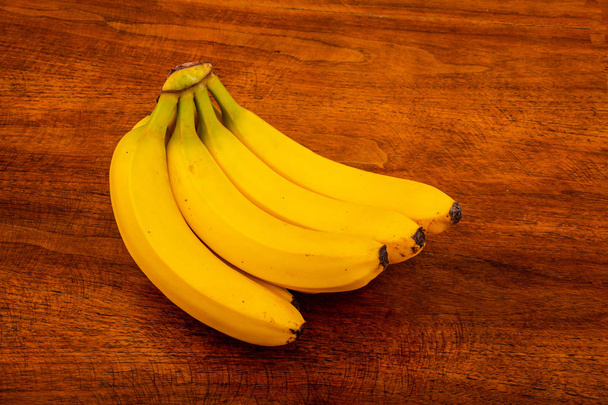 Tuoreet kypsät banaanit puupöydällä
 - Valokuva, kuva