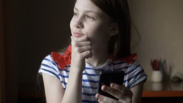 Посміхнена дівчина смс-повідомлення на смартфоні вдома
. - Кадри, відео