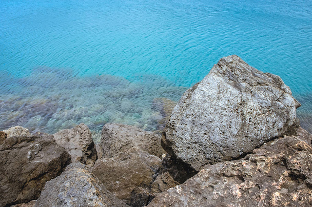 Обломки волнолома на пляже Средиземного моря в городе Киссамос на острове Крит, Греция
 - Фото, изображение