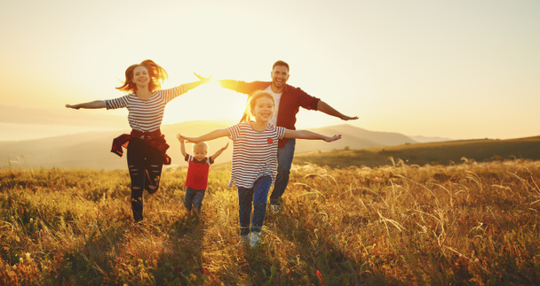 Familia feliz: madre, padre, hijos hijo e hija en la naturaleza en el sol
 - Foto, Imagen