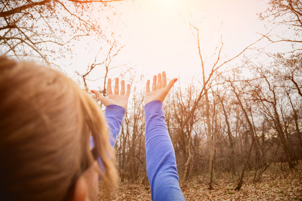 femme heureuse dans les lunettes criant tandis que debout avec les mains levées dans la forêt d'automne au lever du soleil
  - Photo, image