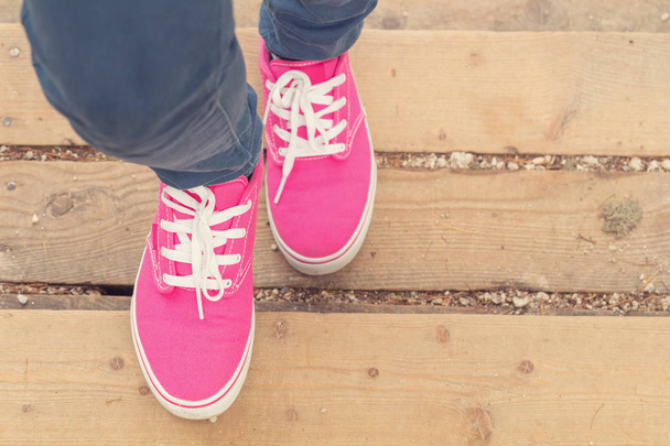 Close-up van vrouwelijke voeten in roze sneakers tijdens het lopen, - Foto, afbeelding