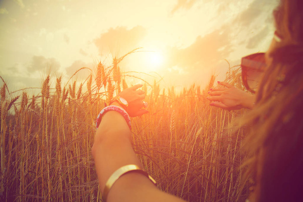 női kezek megható füle árpa réten, napsütéses napon  - Fotó, kép