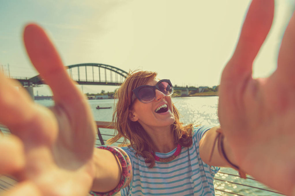 femme prenant selfie sur smartphone tout en se tenant au bord de la mer
  - Photo, image