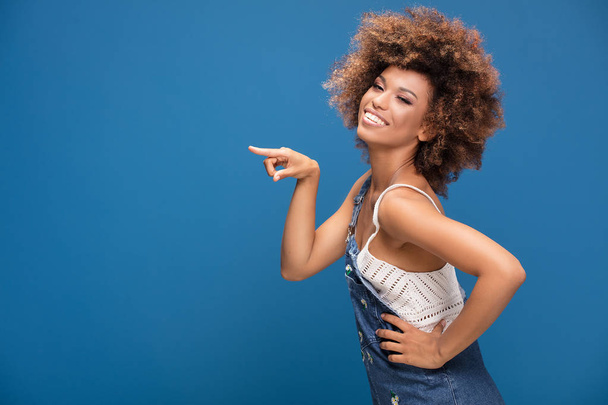 Beauty portrait of african american woman with glamour makeup and afro hairstyle. Girl posing on blue background. - Valokuva, kuva