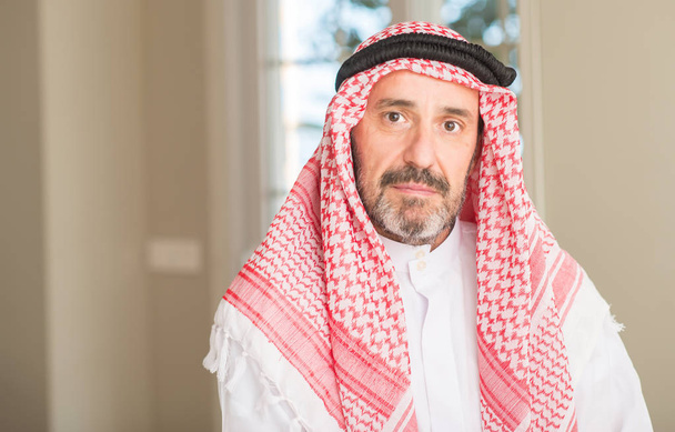 Middle age arabian man at home with a confident expression on smart face thinking serious - Photo, Image