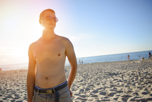 Młody człowiek wreszcie na plaży bez koszulki. Czas letni - Zdjęcie, obraz
