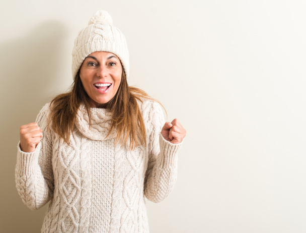 Středního věku žena nosí vlněné zimní čepice křičí hrdá a slaví vítězství a úspěch, velmi vzrušený, fandění emoce - Fotografie, Obrázek