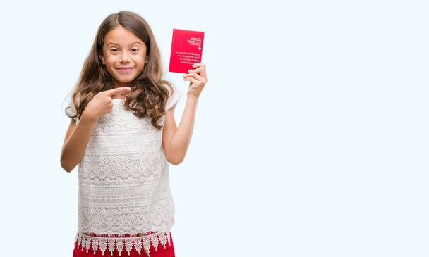 Morena chica hispana con pasaporte de Suiza muy feliz señalando con la mano y el dedo
 - Foto, imagen