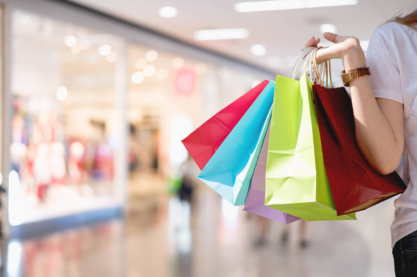 保持している女性ショッピング買い物袋のカラフルなコピー スペースでショッピングのコンセプトのショッピング モールでのクローズ アップ - 写真・画像