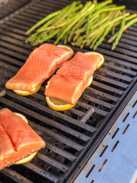 Step by step. Grilling salmon with lemons on outdooor gas grill. - Photo, Image