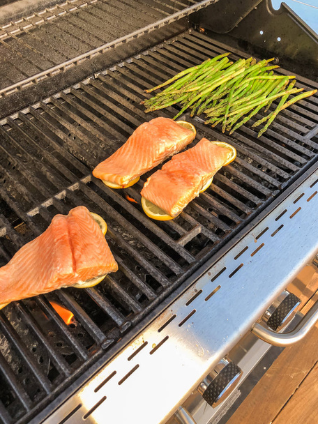 Step by step. Grilling salmon with lemons on outdooor gas grill. - Photo, Image