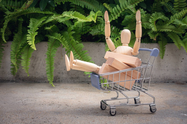 Concetto di shopping., Mini modello umano è seduto nel carrello
. - Foto, immagini