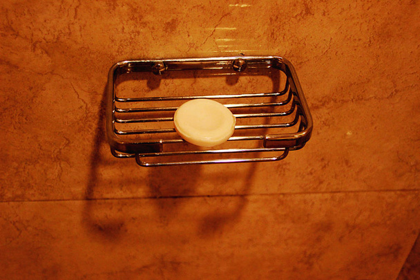 runde Seifenkuchen auf Edelstahl-Seifenständer an Badezimmerwand montiert - Foto, Bild