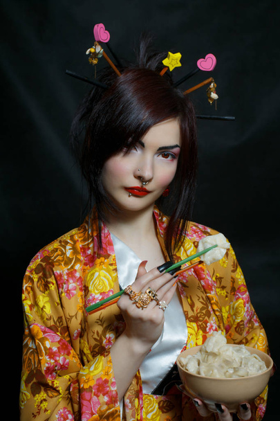 Pretty asian girl in kimono preparing to eat meat dumplings (russian pelmeni) - Foto, Imagen